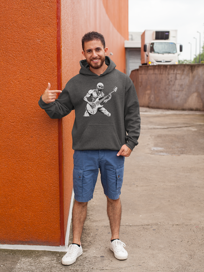 Man wearing a hoodie with a graphic design pointing towards an orange wall.